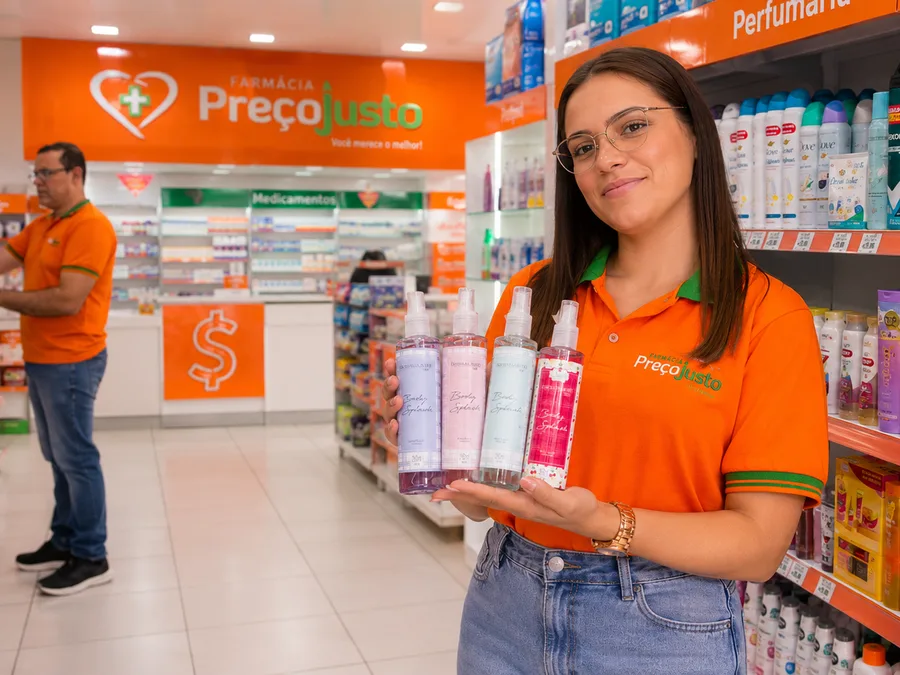 Atendente da Farmácia Preço Justo entregando compra ao cliente